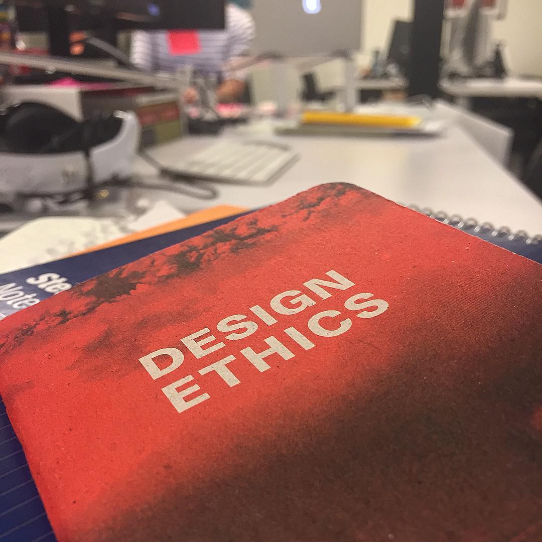 A folder labeled "Design Ethics" on top of a desk.